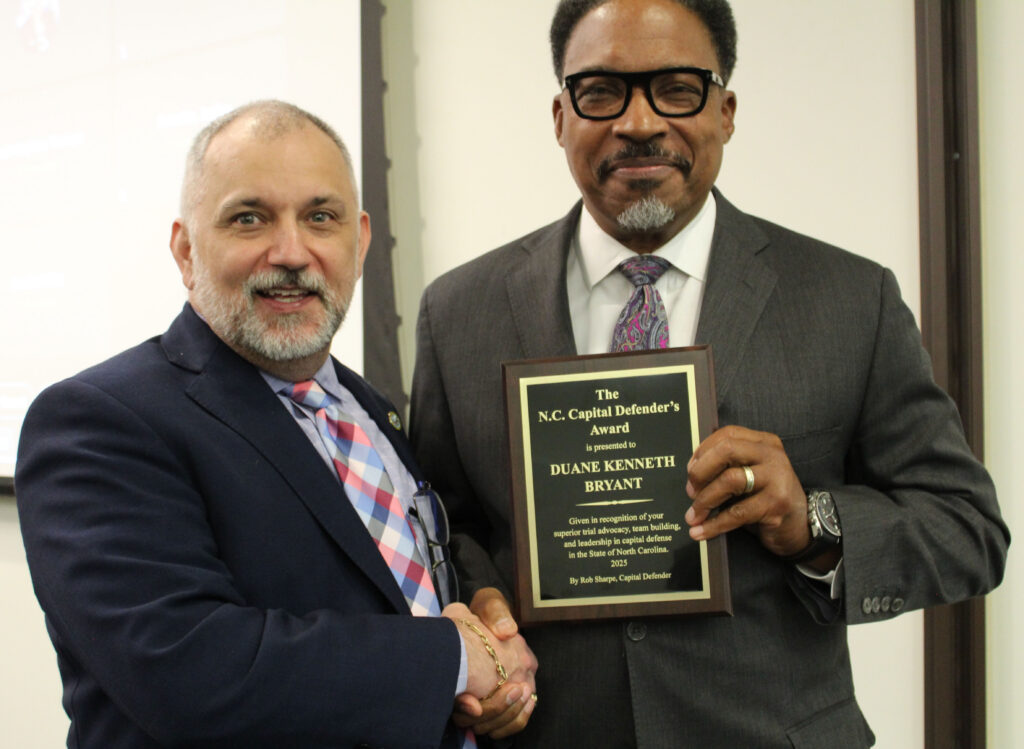 Robert Sharpe and Duane Bryant; two men shaking hands, one holding a plaque